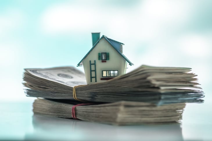 House on top of cash representing a mortgage